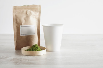 Paper bag, glass and matcha tea on white table