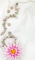 Modern fashion jewellery with charms and pendants on white satin