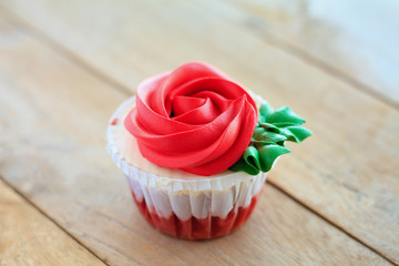 red rose cupcake on wooden table