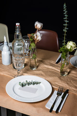 Decorated table ready for dinner. Beautifully decorated table set with flowers, candles, plates and serviettes for wedding or another event in the restaurant.
