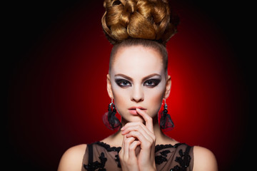 Fototapeta premium Hot young woman model with sexy lips makeup, strong eyebrows, clean shiny skin and bun hairstyle. Beautiful fashion portrait of glamour female face