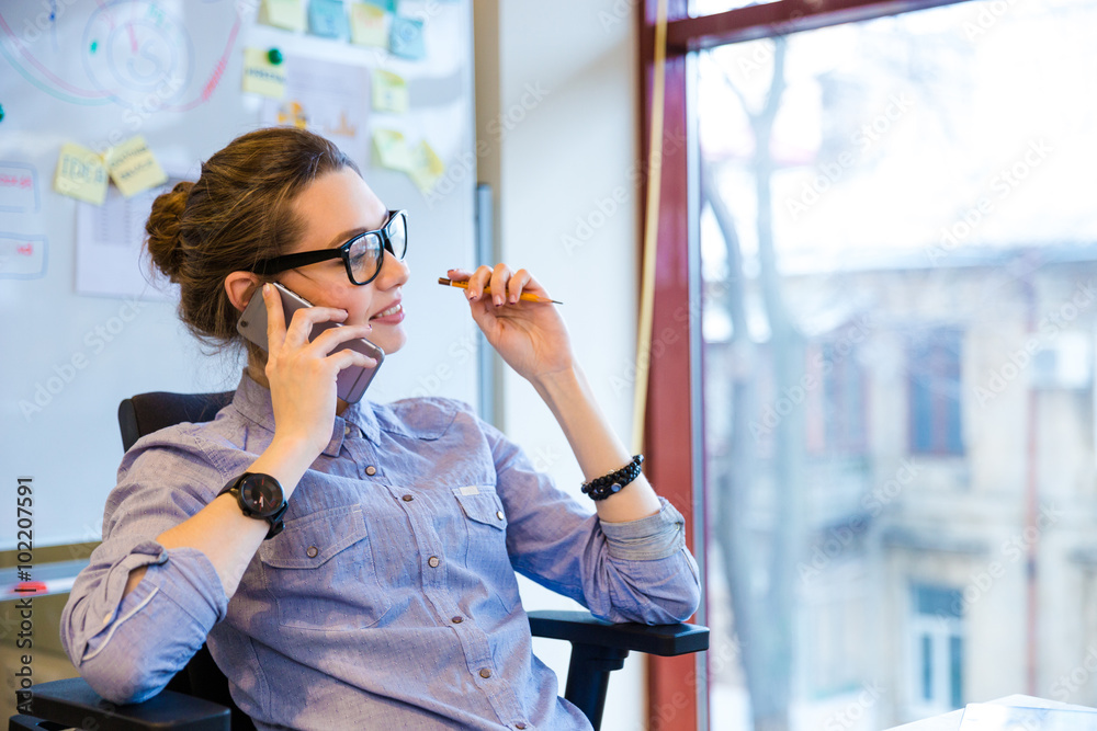 Poster Happy business woman talking on cell phone in office