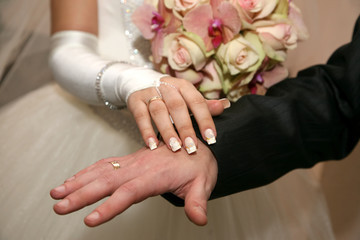 Obraz na płótnie Canvas hands of the bride and groom together