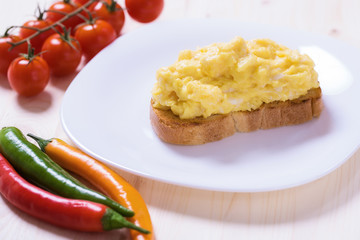 English style scrambled eggs on toast with vegetables
