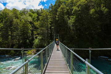 Obraz premium kobieta turysta z plecakiem chodzenie na most wiszący