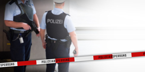 Rücken- und Seitenansicht von Polizisten am Flughafen Frankfurt mit Absperrband und Textfreiraum