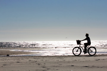 Fototapeta na wymiar Fahrradfahrerin am Strand Rømø