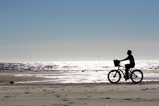 Fahrradfahrerin am Strand R&oslash;m&oslash;