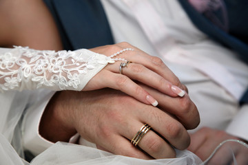Obraz na płótnie Canvas bride and groom show their hands wearing wedding rings