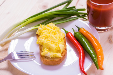 American style scrambled eggs on toast with
a glass of juice

