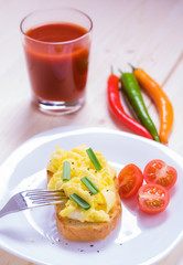 American style scrambled eggs on toast with
a glass of juice
