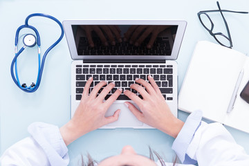 Female doctor hands working on laptop