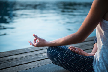 Meditation detail. Woman meditating by the lake
