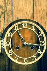 Retro clock on wooden wall background. Concept of time.