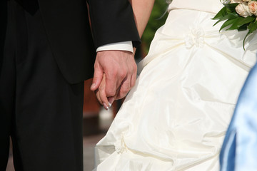 groom holds the bride by the hand closeup