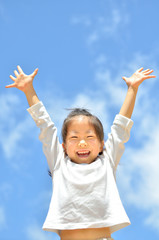 青空でバンザイする女の子