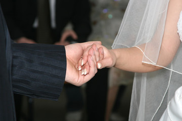 groom holds the bride by the hand closeup