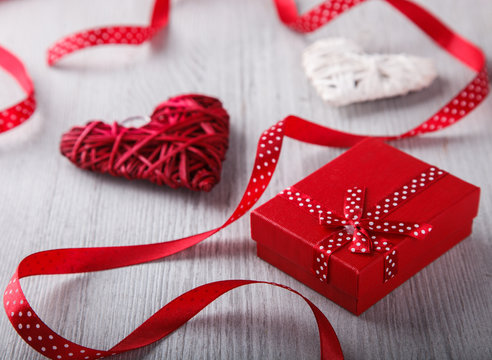 Gift and the heart is decorated with a red ribbon for a romantic Valentine's day celebration, on a light background.selective focus.