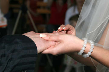 Obraz na płótnie Canvas bride and groom wear wedding rings to each other