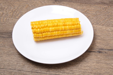 fresh boiled cob corn on a wooden plate