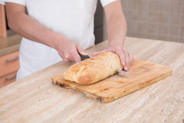 man cutting bread