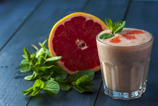 Glass of homemade smoothie with grapefruit, banana and mint leaves . Conception of healthy food.  Nonalcoholic drinks.