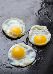 Fried eggs on black background
