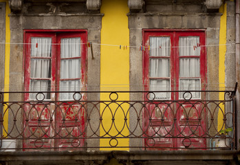 Balcony in Porto. Red doors contrast with yellow trim in a display of colour in Porto, a historical town in Portugal.