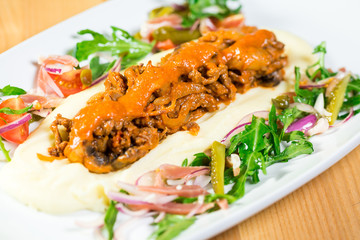 Beautiful original dish with pickles and grilled meat with a side dish of potatoes