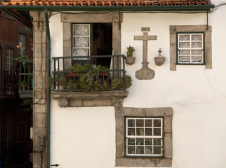 Fototapeta na wymiar Historical Windows. A series of stone framed windows covered in crocheted curtains is very typical of Portugal. 