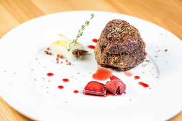 Beautiful juicy well done a piece of meat with sauce on a wooden table