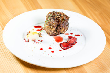 Beautiful juicy well done a piece of meat with sauce on a wooden table
