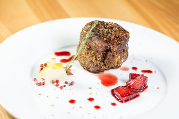 Beautiful juicy well done a piece of meat with sauce on a wooden table