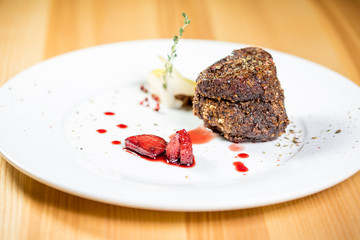Beautiful juicy well done a piece of meat with sauce on a wooden table