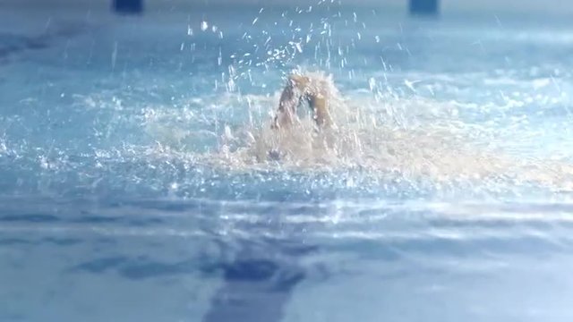 Shot from Front Side of Professional Swimmer Performing Butterfly Stroke during Training in Swimming Pool. Shot on RED Cinema Camera.