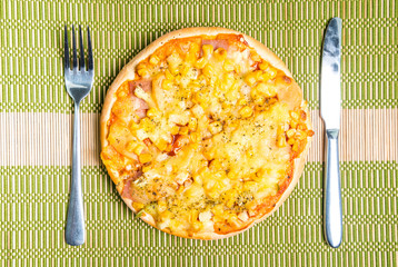 Hawaiian pizza on the table.