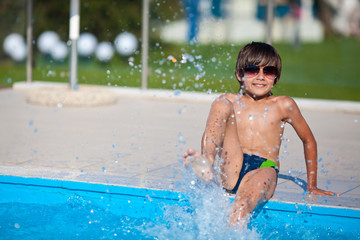 Boy sitting by the pool on vacation