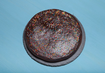 Homemade chocolate cake on blue wooden background