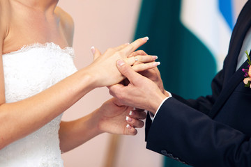 groom dresses a ring on  finger to the bride