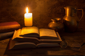 old books, candle and copper jugs