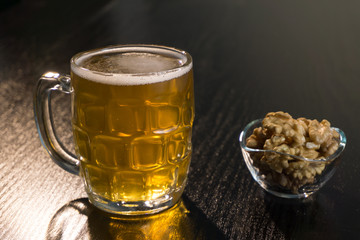 beer on the dark black wood near beer nuts