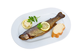 Eine geräucherte Forelle auf weißer, freigestellter Platte mit Meerrettich und Baguette - a smoked rainbow trout on a white plate isolated on white background