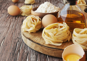 Uncooked pasta with flour on the table, selective focus