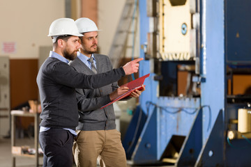 Two businessman working in factory
