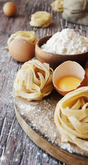Uncooked pasta with flour on the table, selective focus