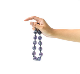 beautiful hand of a young woman holding white necklace on white