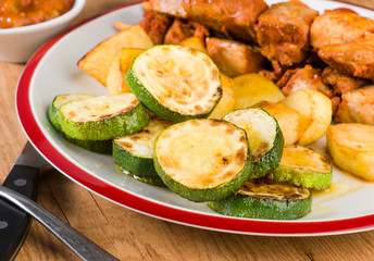 skewered meat and vegetables on wooden plate