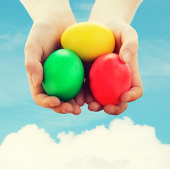 close up of kid hands holding colored eggs