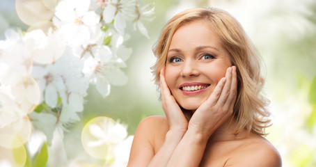 smiling woman with bare shoulders touching face