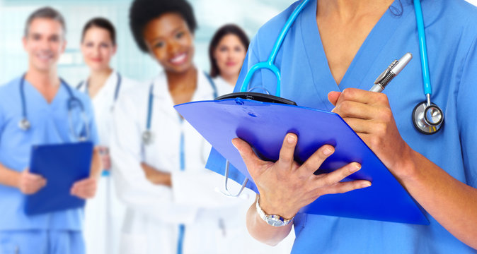 Doctor hands writing on a clipboard.